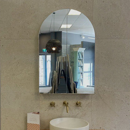 Bathroom vanity with a white sink and wooden cabinet against a beige wall.
